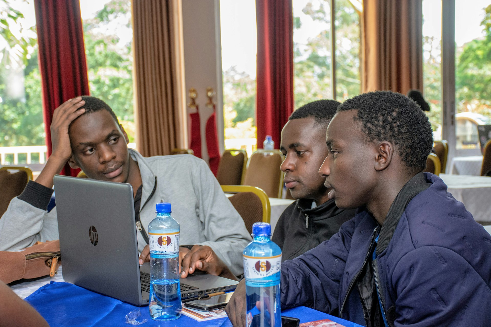 three men using laptops on table